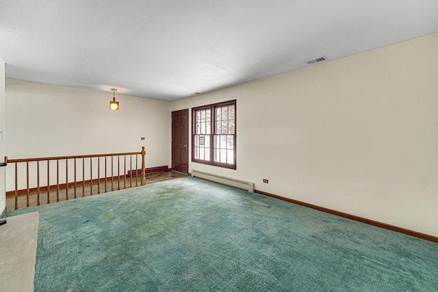 spare room with carpet flooring and a baseboard heating unit