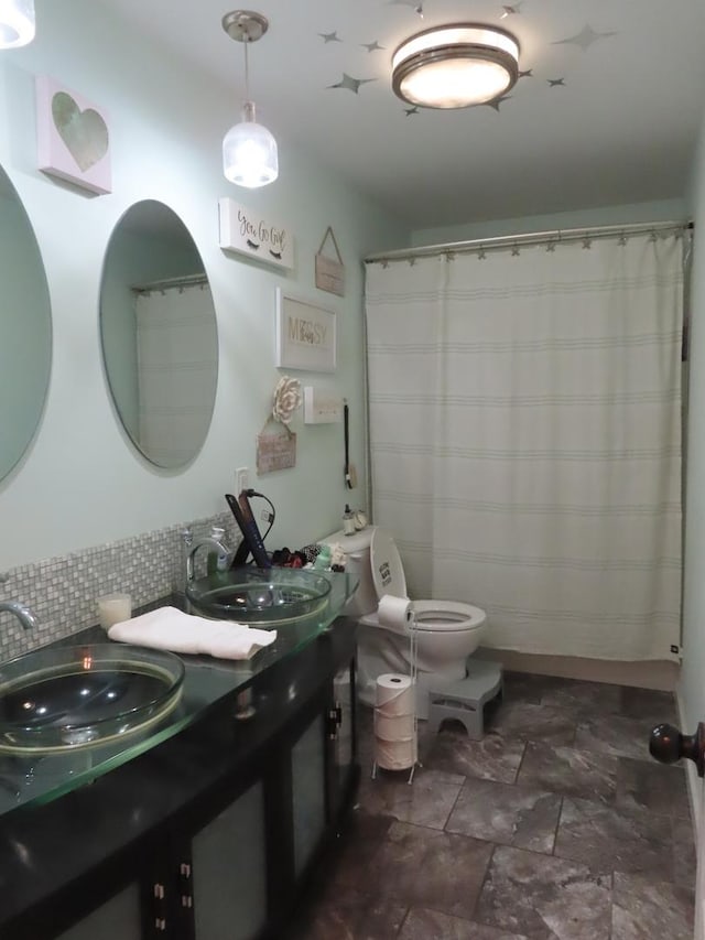 bathroom with vanity, toilet, and backsplash