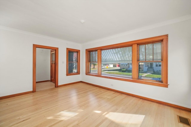 spare room featuring light hardwood / wood-style flooring and ornamental molding