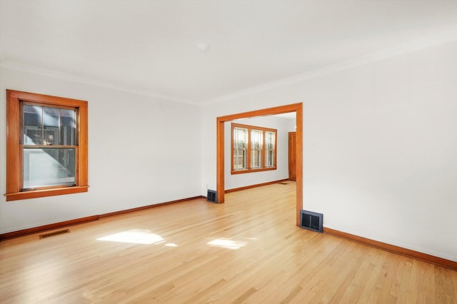 unfurnished room featuring light wood-type flooring and ornamental molding