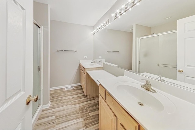 bathroom with vanity and a shower with door