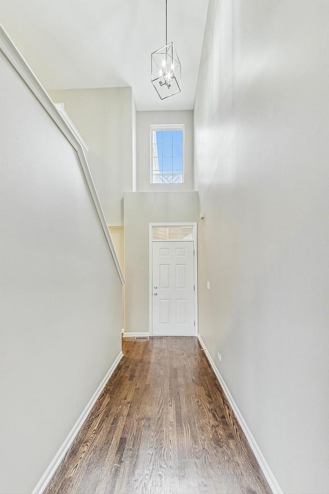 foyer featuring hardwood / wood-style flooring, a notable chandelier, and a high ceiling