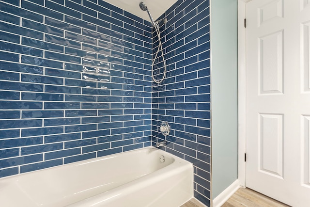 bathroom featuring wood-type flooring and  shower combination