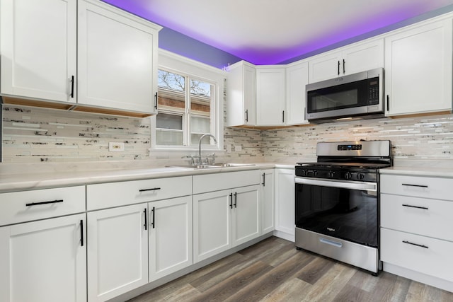 kitchen with decorative backsplash, sink, white cabinets, and stainless steel appliances