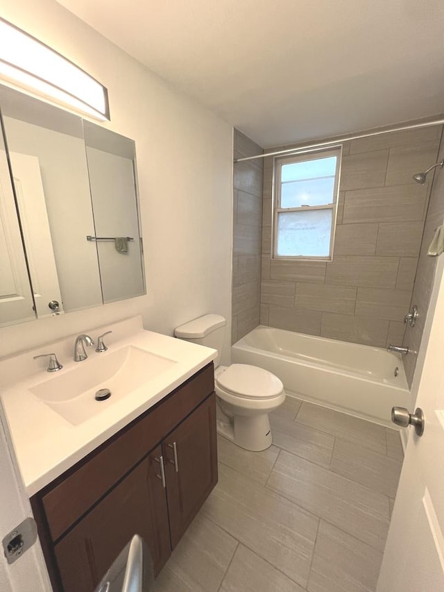 full bathroom featuring tile patterned floors, vanity, toilet, and tiled shower / bath combo