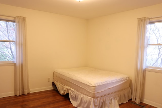 bedroom featuring dark hardwood / wood-style flooring and multiple windows