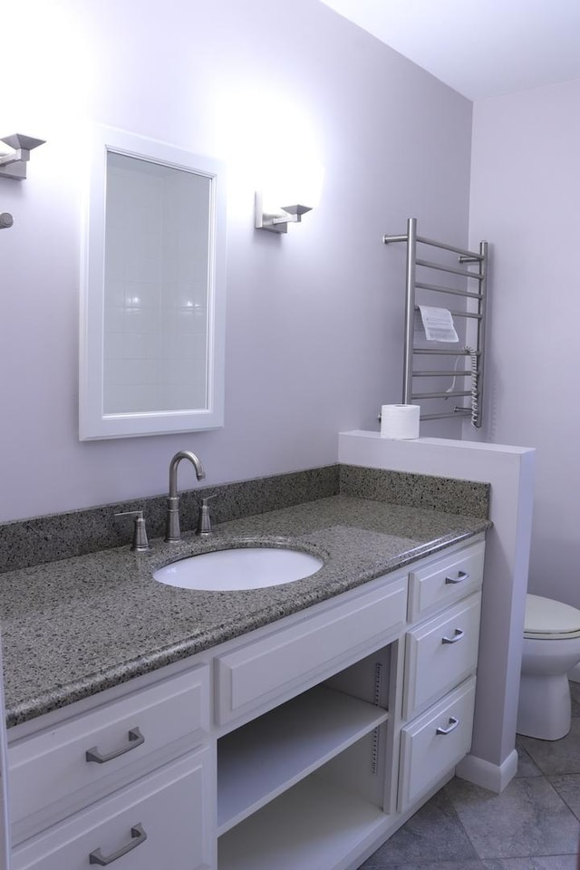 bathroom with tile patterned flooring, radiator heating unit, vanity, and toilet