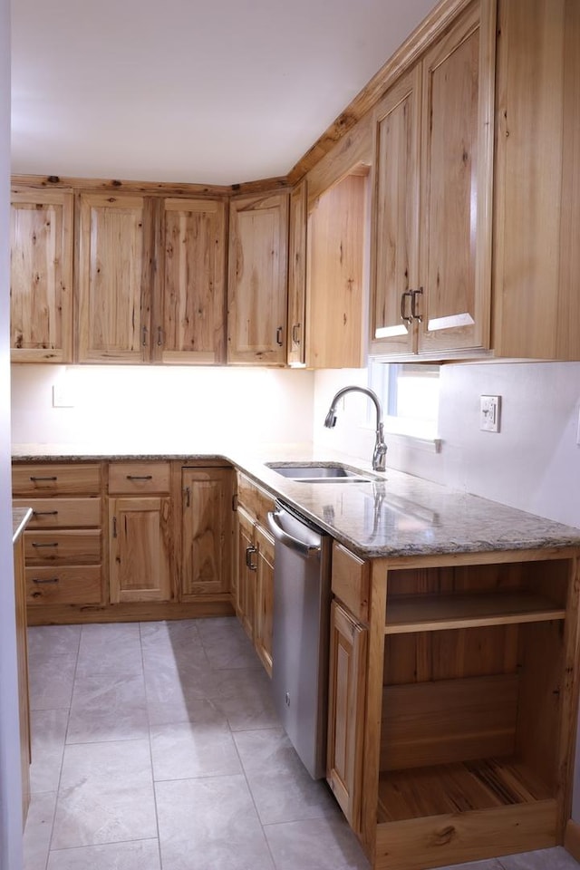 kitchen featuring dishwasher, light tile patterned floors, light stone counters, and sink