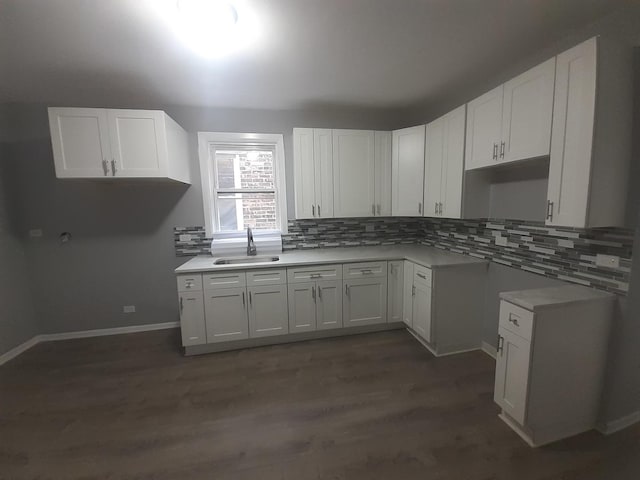 kitchen with decorative backsplash, white cabinetry, sink, and dark wood-type flooring