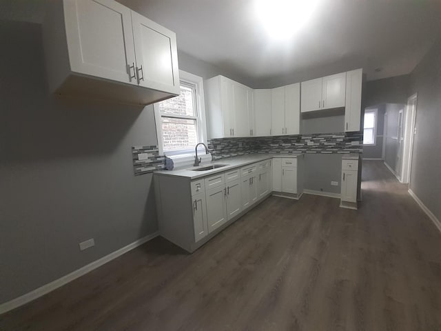 kitchen featuring white cabinets, decorative backsplash, dark hardwood / wood-style floors, and sink