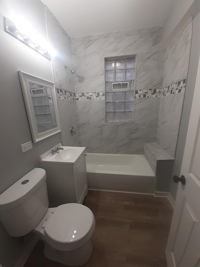 full bathroom with hardwood / wood-style flooring, vanity, toilet, and tiled shower / bath combo