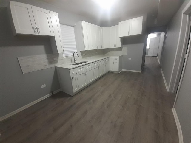 kitchen with decorative backsplash, dark hardwood / wood-style floors, white cabinetry, and sink