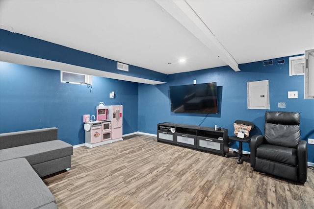 living room with electric panel, beamed ceiling, and hardwood / wood-style flooring