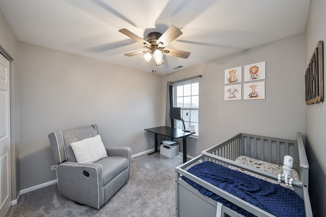 bedroom featuring ceiling fan, carpet floors, and a nursery area