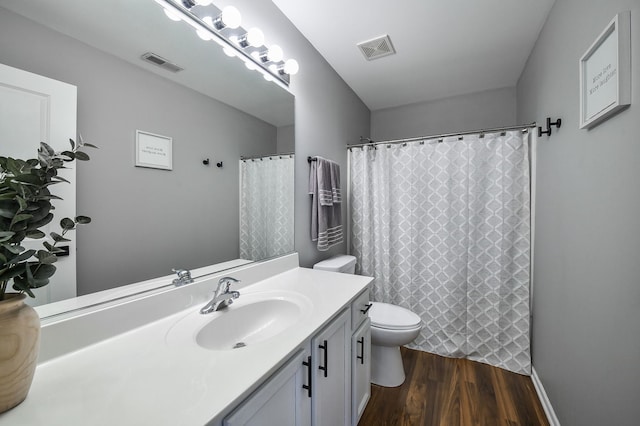 bathroom featuring wood-type flooring, vanity, and toilet