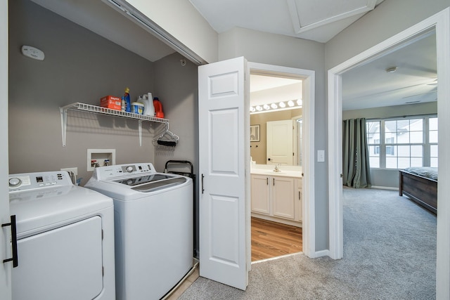 laundry area with washer and dryer, light colored carpet, and sink