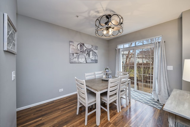 dining space with an inviting chandelier and dark wood-type flooring