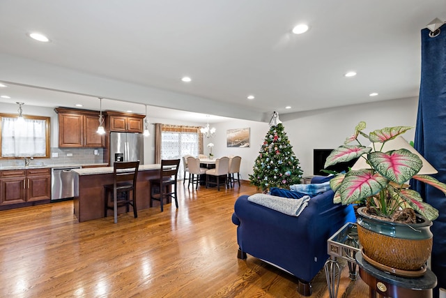 living room with dark hardwood / wood-style floors, a notable chandelier, and sink