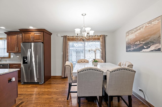 dining room featuring a notable chandelier and dark wood-type flooring