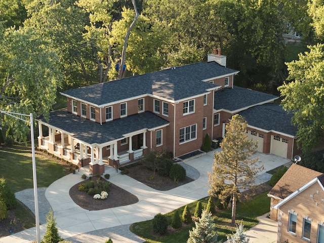 view of front of property featuring a garage, a porch, and a front yard