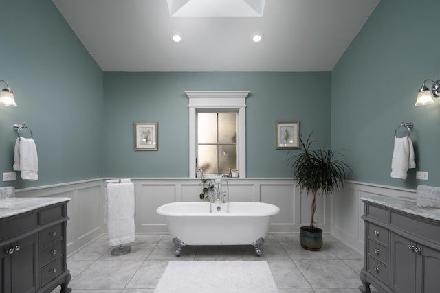 bathroom with tile patterned flooring, a washtub, and vanity