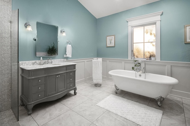 bathroom featuring vanity, vaulted ceiling, and a bathing tub