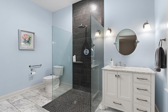 bathroom with vanity, toilet, and a tile shower