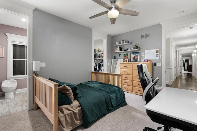 bedroom with ceiling fan, carpet floors, ensuite bathroom, and a closet