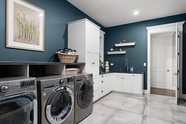 washroom featuring cabinets, sink, and washing machine and clothes dryer