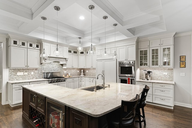 kitchen with a large island, stainless steel appliances, coffered ceiling, and sink