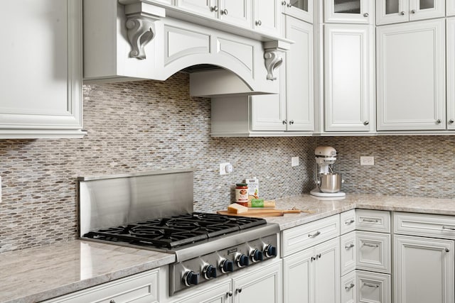 kitchen with stainless steel gas stovetop, white cabinetry, and tasteful backsplash