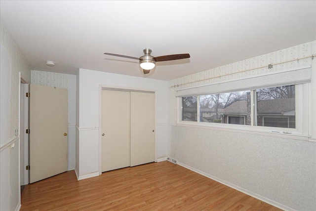 unfurnished bedroom with ceiling fan, a closet, and light hardwood / wood-style flooring