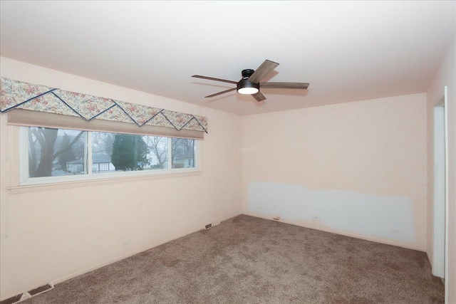 carpeted spare room with ceiling fan