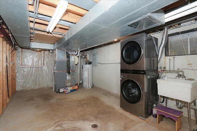 basement featuring sink, heating unit, stacked washer and clothes dryer, and water heater