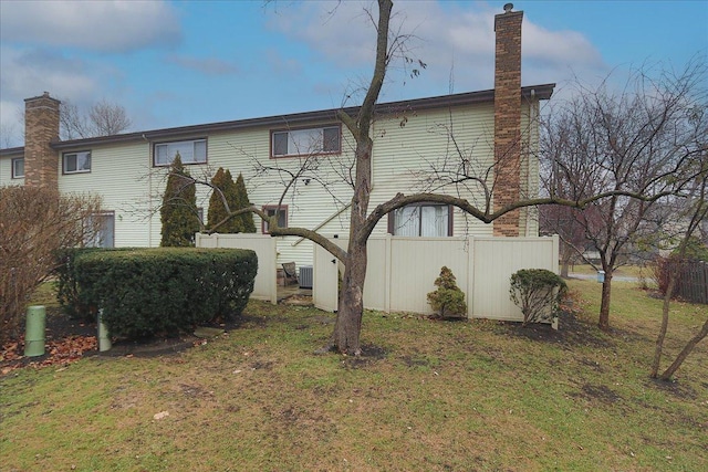 back of property featuring a lawn and central AC unit