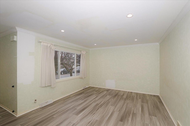 empty room featuring light hardwood / wood-style floors and crown molding