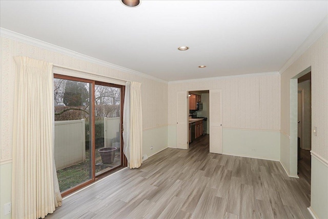 unfurnished room featuring light wood-type flooring and crown molding