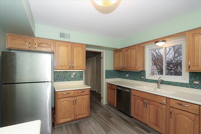 kitchen with backsplash, stainless steel refrigerator, dishwasher, and sink