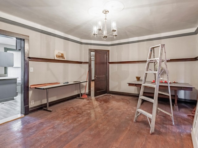 basement featuring crown molding, wood-type flooring, and an inviting chandelier