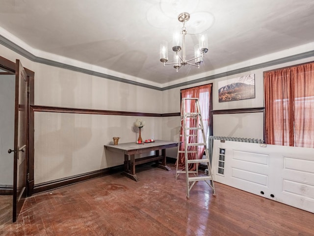 interior space featuring hardwood / wood-style flooring, a notable chandelier, and crown molding