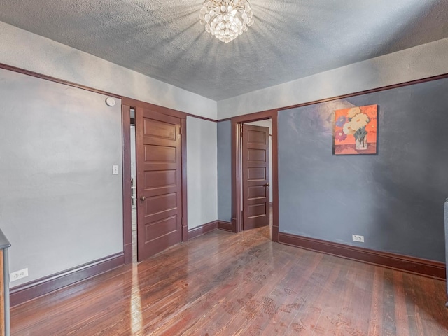 interior space featuring hardwood / wood-style flooring, a notable chandelier, and a textured ceiling