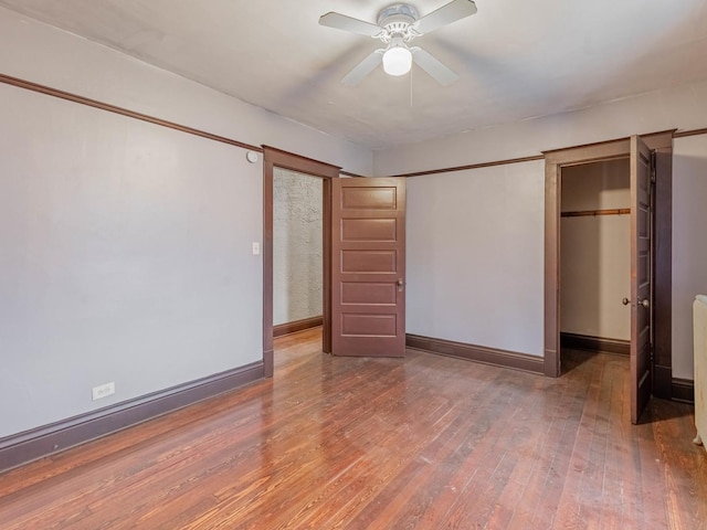 unfurnished bedroom with ceiling fan and hardwood / wood-style flooring