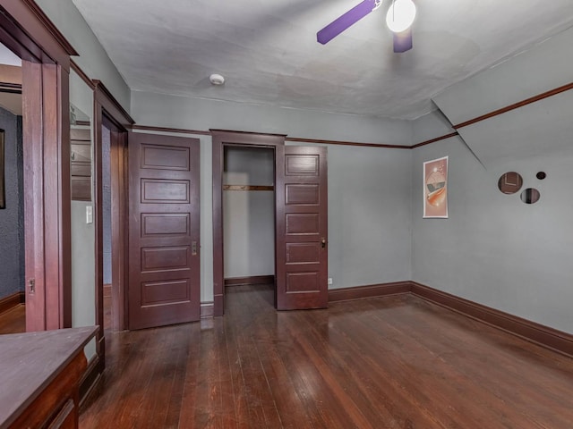 unfurnished bedroom with ceiling fan, dark hardwood / wood-style floors, and a closet