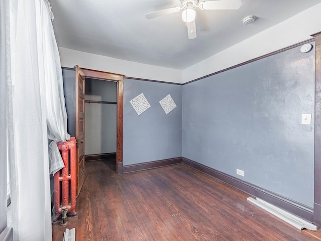 unfurnished bedroom featuring dark hardwood / wood-style flooring, ceiling fan, and a closet