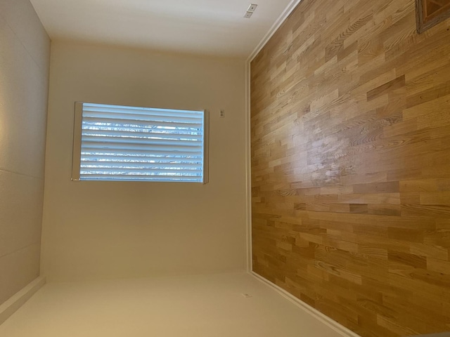 unfurnished room featuring wood walls