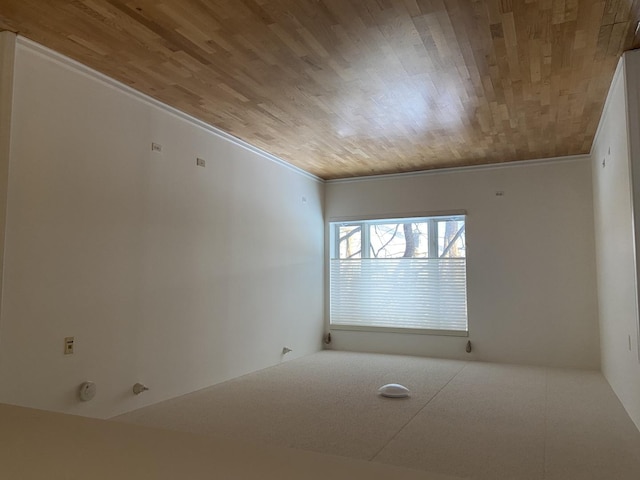 empty room featuring crown molding and wooden ceiling