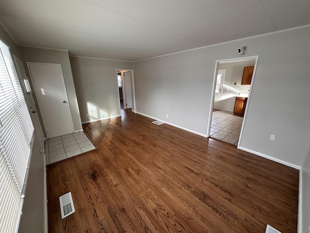 unfurnished living room featuring hardwood / wood-style floors and crown molding