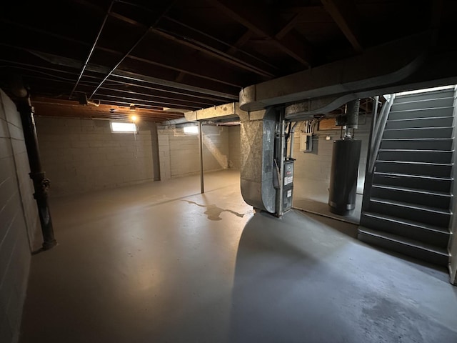 basement with electric panel, gas water heater, and heating unit