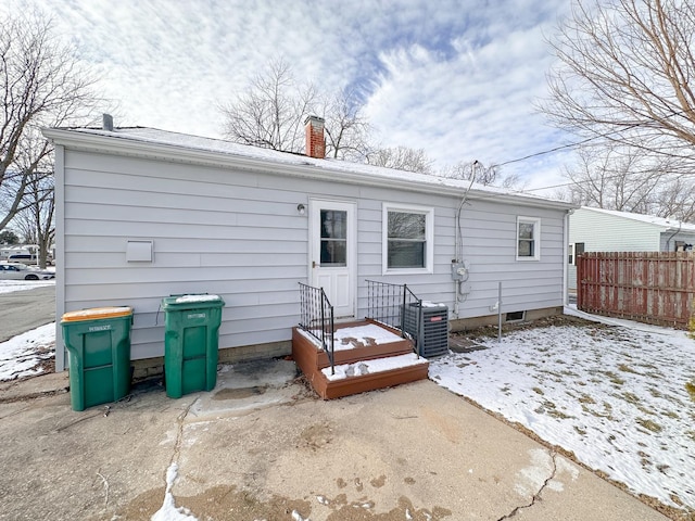 snow covered rear of property with cooling unit