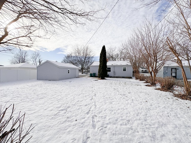 yard layered in snow featuring an outbuilding